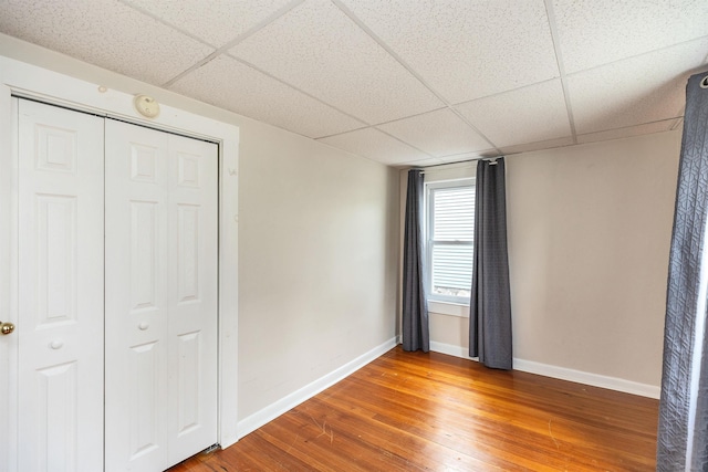 247 Prospect St, Manchester, NH 03104 - unfurnished bedroom with a drop ceiling, baseboards, wood finished floors, and a closet