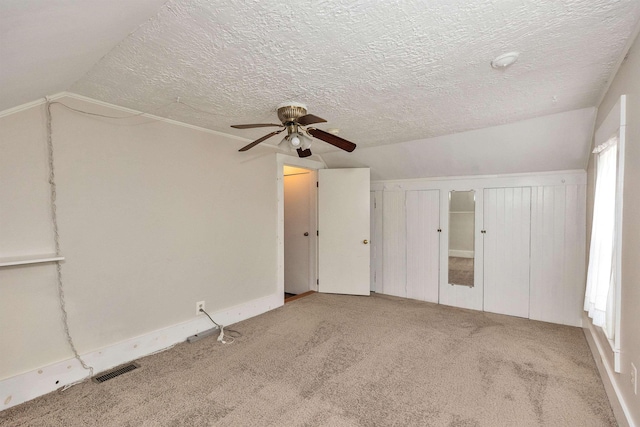 247 Prospect St, Manchester, NH 03104 - unfurnished bedroom featuring carpet flooring, vaulted ceiling, ceiling fan, multiple closets, and a textured ceiling