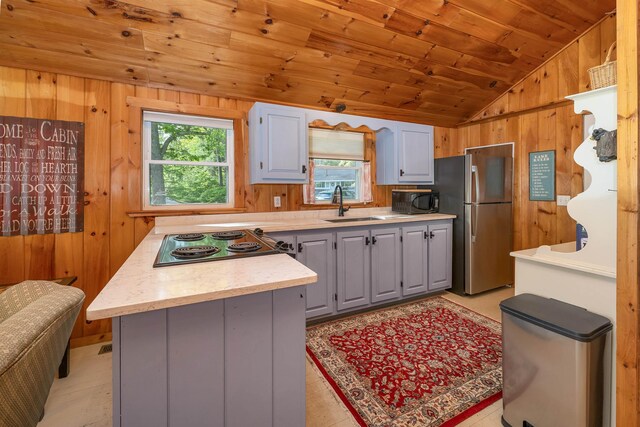 22 Shore Dr, Middleton, NH 03887 - kitchen with wood ceiling, lofted ceiling, wood walls, freestanding refrigerator, and a sink