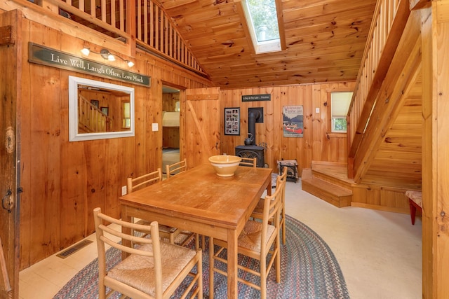 22 Shore Dr, Middleton, NH 03887 - dining room with a wood stove, wooden walls, vaulted ceiling, a skylight, and wooden ceiling