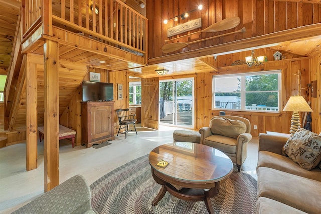 22 Shore Dr, Middleton, NH 03887 - living room featuring wood walls, healthy amount of natural light, a chandelier, and high vaulted ceiling