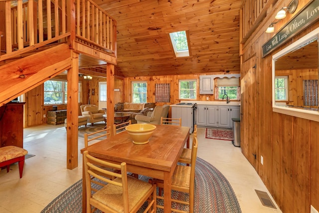 22 Shore Dr, Middleton, NH 03887 - dining room with wooden walls, healthy amount of natural light, a skylight, high vaulted ceiling, and light flooring