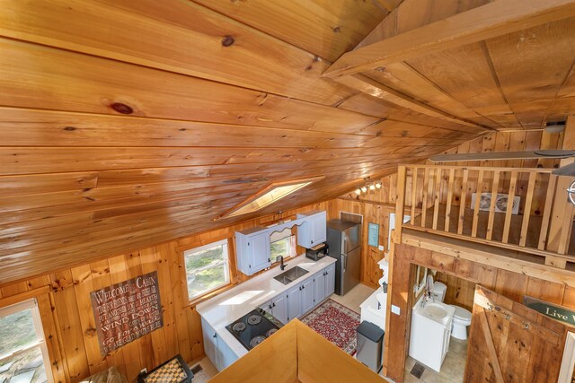 22 Shore Dr, Middleton, NH 03887 - unfurnished living room featuring lofted ceiling, wood walls, wood ceiling, and a sink
