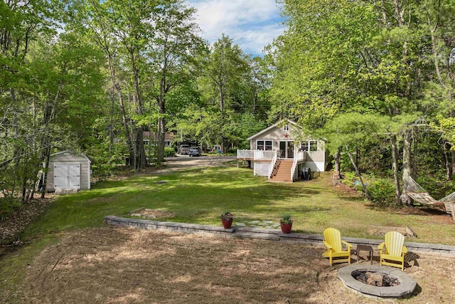 22 Shore Dr, Middleton, NH 03887 - view of grassy yard with a fire pit, stairway, and a deck