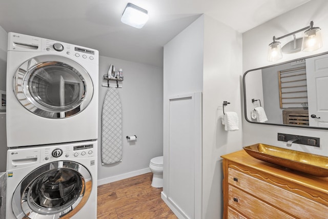 25 Hilltop Dr, Newbury, NH 03255 - washroom with stacked washer and clothes dryer, light wood-style flooring, and baseboards