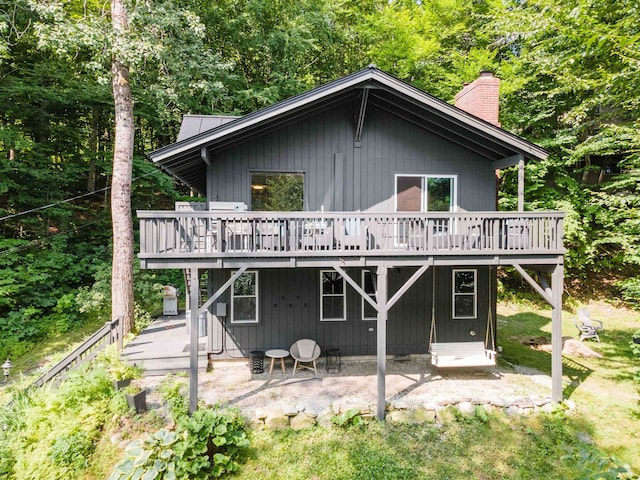 25 Hilltop Dr, Newbury, NH 03255 - rear view of house featuring a patio, a deck, a chimney, and a forest view