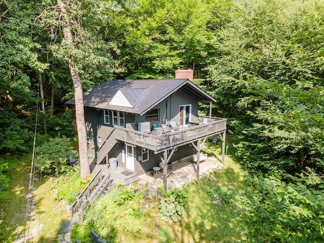 25 Hilltop Dr, Newbury, NH 03255 - rear view of house featuring stairway, a chimney, a deck, a patio area, and a wooded view