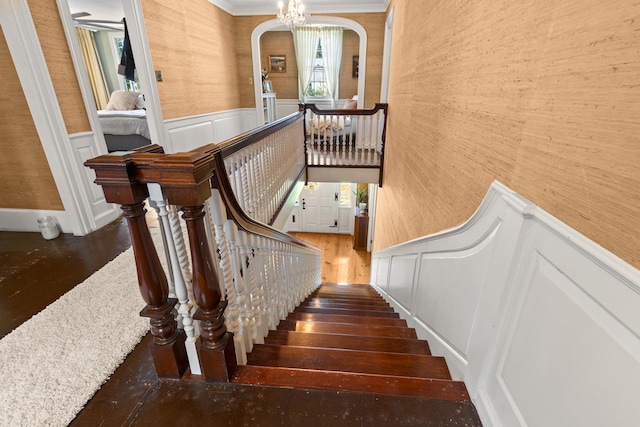 79 Silver St, Dover, NH 03820 - staircase with hardwood / wood-style floors, a decorative wall, ornamental molding, a wainscoted wall, and arched walkways