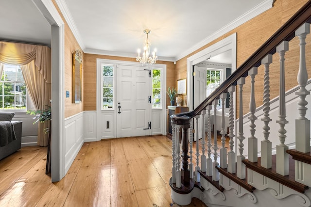 79 Silver St, Dover, NH 03820 - entryway with a chandelier, light wood-type flooring, a wainscoted wall, stairs, and ornamental molding