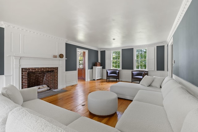 79 Silver St, Dover, NH 03820 - living area featuring a decorative wall, light wood-type flooring, a fireplace with flush hearth, a wainscoted wall, and crown molding
