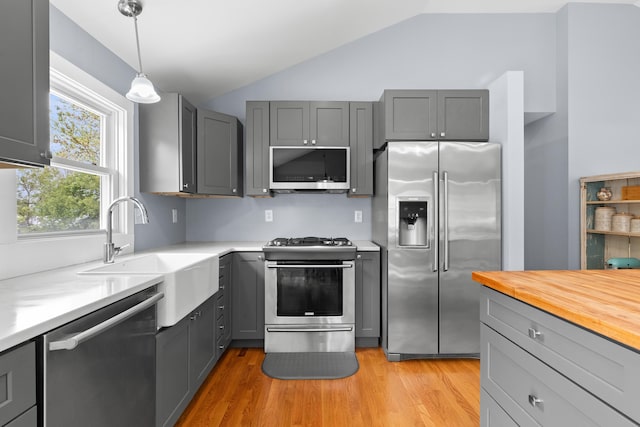 4 Crestview Ter, Stratham, NH 03885 - kitchen featuring appliances with stainless steel finishes, a sink, gray cabinetry, vaulted ceiling, and light wood finished floors