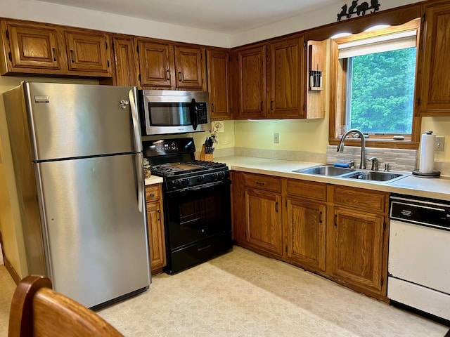 348 Ridge Rd, Northwood, NH 03261 - kitchen with stainless steel appliances, a sink, light countertops, and brown cabinets