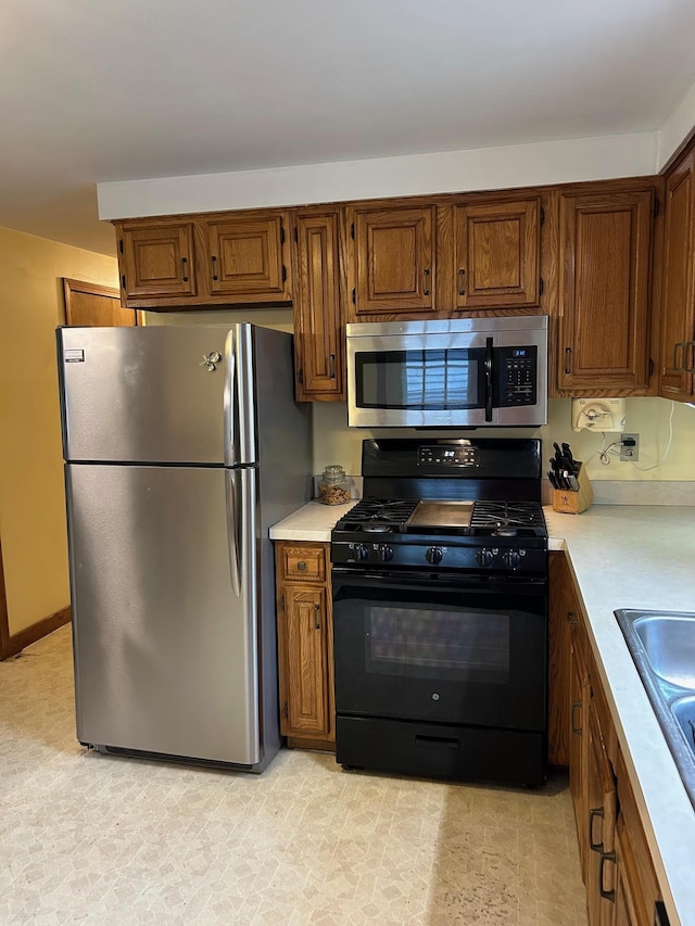348 Ridge Rd, Northwood, NH 03261 - kitchen featuring appliances with stainless steel finishes, light countertops, brown cabinets, and a sink