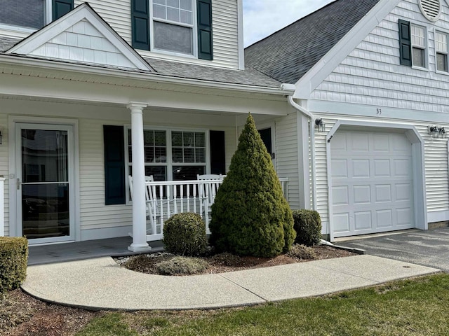 4 Bow Center Rd Unit B-3, Bow, NH 03304 - view of exterior entry with a porch, a shingled roof, asphalt driveway, and an attached garage