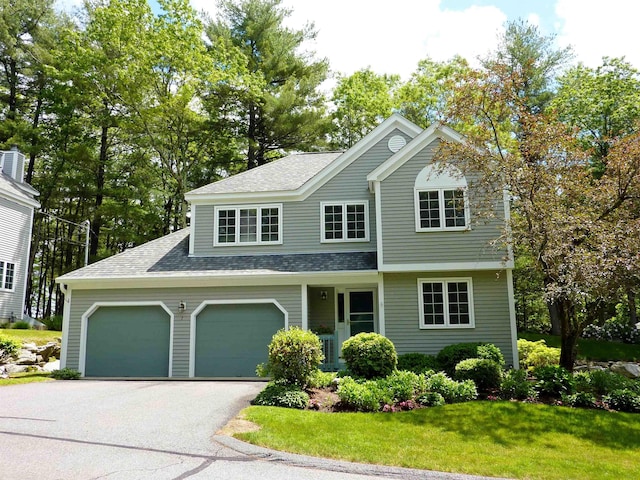 7 Lilac Ct Unit 335, Nashua, NH 03062 - view of front facade with roof with shingles, driveway, an attached garage, and a front lawn