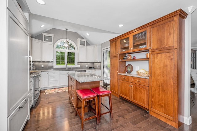 7 Lilac Ct Unit 335, Nashua, NH 03062 - kitchen with dark wood finished floors, stainless steel range with electric cooktop, a sink, light stone countertops, and vaulted ceiling