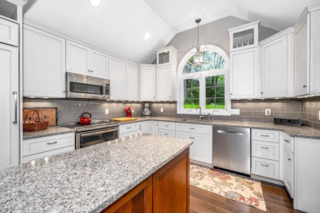 7 Lilac Ct Unit 335, Nashua, NH 03062 - kitchen with appliances with stainless steel finishes, a sink, vaulted ceiling, light stone countertops, and recessed lighting