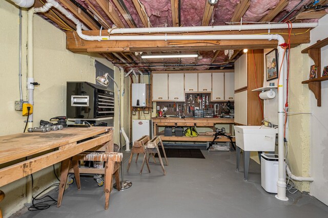 7 Lilac Ct Unit 335, Nashua, NH 03062 - below grade area featuring a workshop area, tankless water heater, and a sink