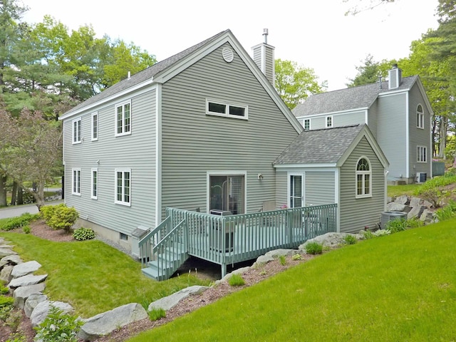 7 Lilac Ct Unit 335, Nashua, NH 03062 - rear view of house featuring roof with shingles, a chimney, a wooden deck, a lawn, and central AC