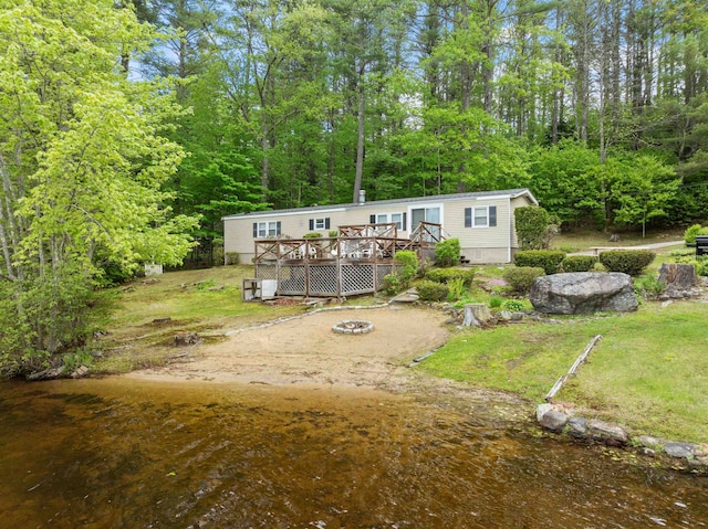 21 Pine Hill Dr, Barnstead, NH 03225 - back of house with a deck, a fire pit, a lawn, and a wooded view
