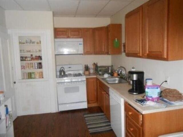 35-37 Courtland St, Nashua, NH 03060 - kitchen featuring white appliances, a sink, brown cabinetry, and light countertops