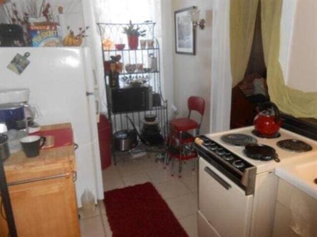 35-37 Courtland St, Nashua, NH 03060 - kitchen with white appliances, light tile patterned flooring, and light countertops