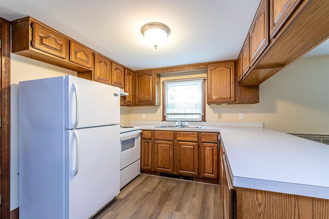 212 W Main St, Hillsborough, NH 03244 - kitchen featuring white appliances, a sink, brown cabinets, light wood-style floors, and light countertops