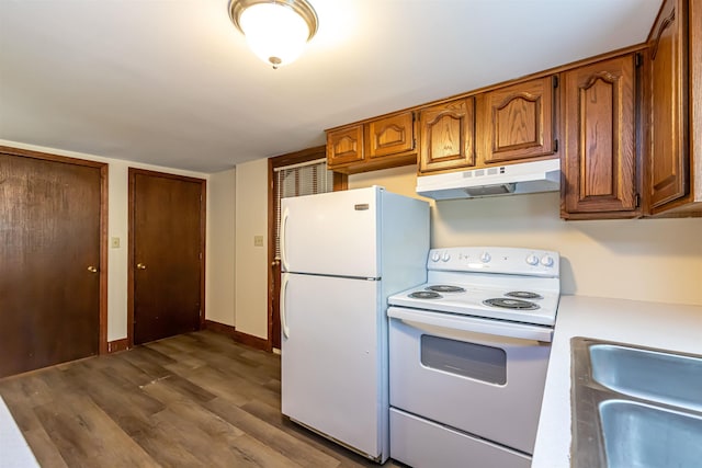 212 W Main St, Hillsborough, NH 03244 - kitchen featuring under cabinet range hood, white appliances, dark wood-style floors, brown cabinetry, and light countertops