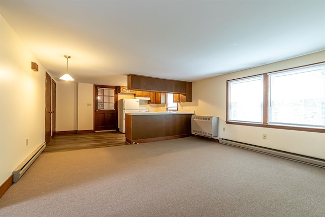 212 W Main St, Hillsborough, NH 03244 - kitchen featuring a baseboard heating unit, a peninsula, carpet floors, and under cabinet range hood