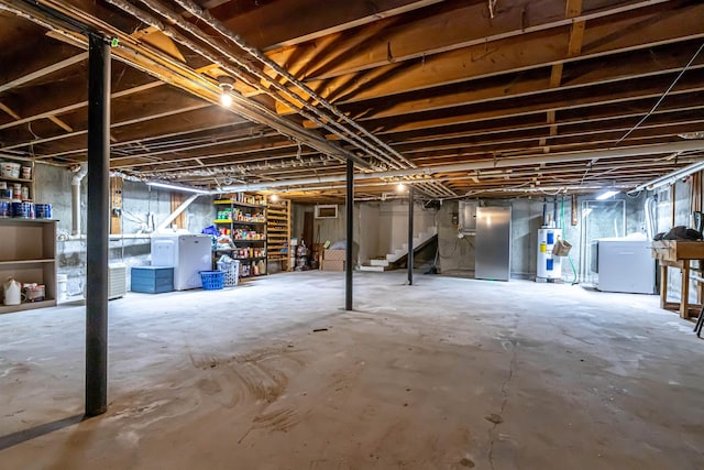 212 W Main St, Hillsborough, NH 03244 - unfinished below grade area featuring electric water heater, washing machine and clothes dryer, stairway, and freestanding refrigerator