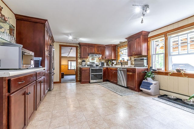 212 W Main St, Hillsborough, NH 03244 - kitchen with appliances with stainless steel finishes, under cabinet range hood, light countertops, and decorative backsplash