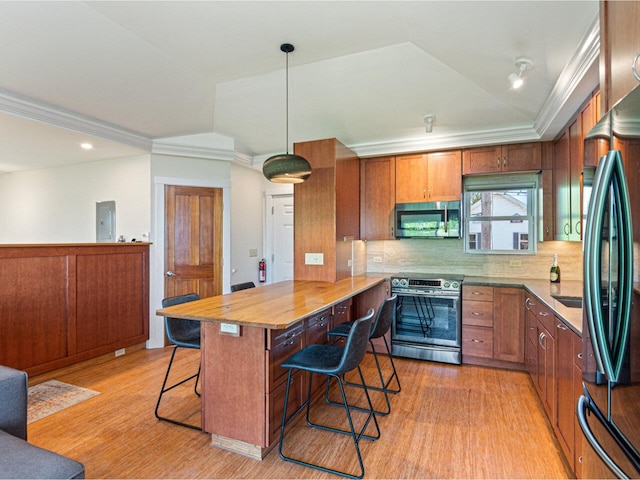 71 N Ave Unit 203, Burlington, VT 05401 - kitchen featuring appliances with stainless steel finishes, a kitchen bar, light wood-style flooring, brown cabinetry, and ornamental molding