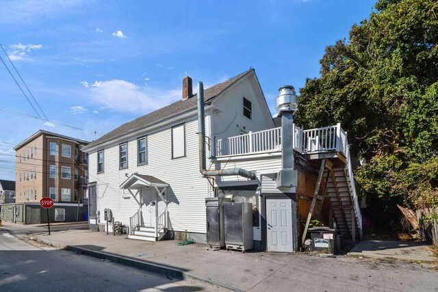 521 Wilson St, Manchester, NH 03103 - view of front of house with entry steps, stairway, and a chimney