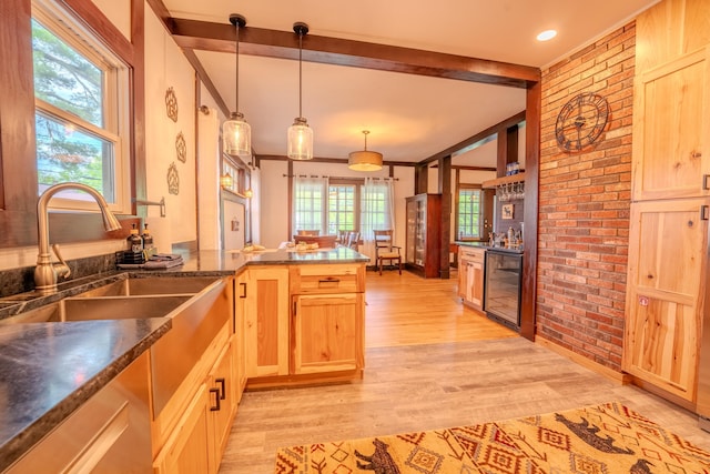 57 Main St, Woodstock, NH 03262 - kitchen with wine cooler, brick wall, light wood finished floors, a peninsula, and light brown cabinetry