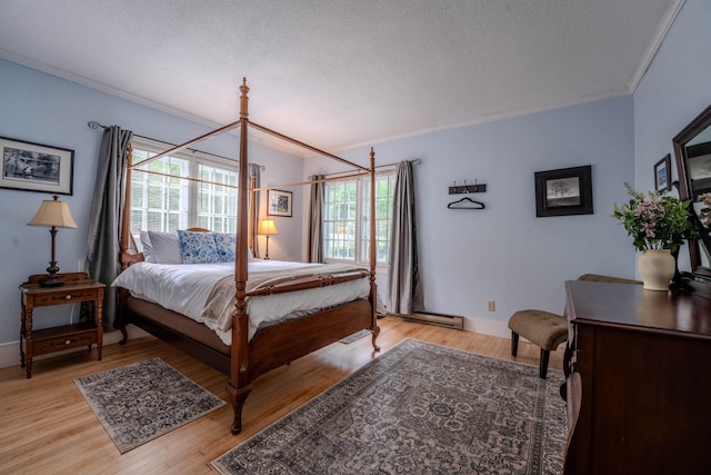57 Main St, Woodstock, NH 03262 - bedroom with multiple windows, crown molding, a textured ceiling, light wood finished floors, and a baseboard radiator