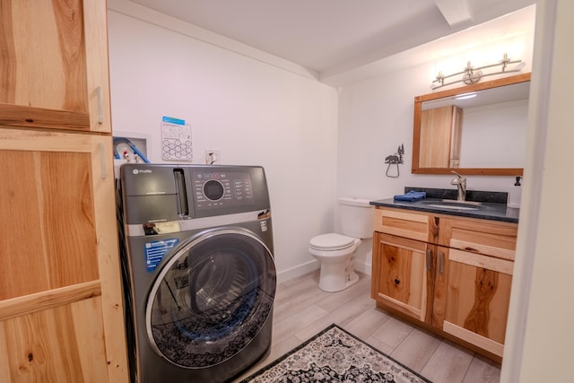 57 Main St, Woodstock, NH 03262 - bathroom featuring washer / dryer, vanity, wood finished floors, toilet, and baseboards
