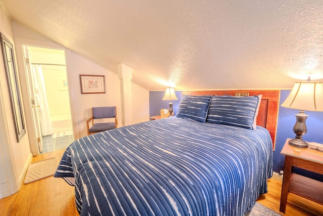 57 Main St, Woodstock, NH 03262 - bedroom with hardwood / wood-style flooring, a textured ceiling, vaulted ceiling, and baseboards