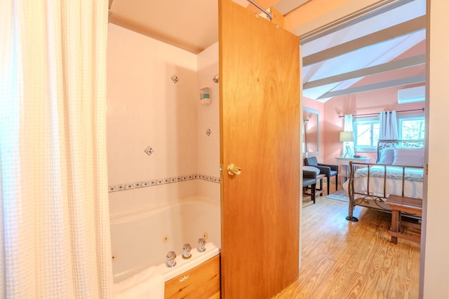 57 Main St, Woodstock, NH 03262 - bathroom with wood finished floors, a combined bath / shower with jetted tub, and a wall unit AC