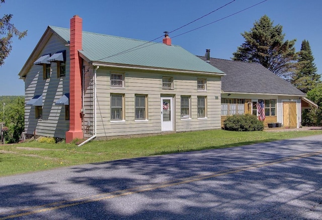 398 N Rd, Milton, VT 05468 - view of front of house with a chimney, metal roof, and a front yard