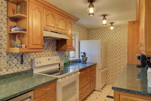 398 N Rd, Milton, VT 05468 - kitchen featuring white appliances, under cabinet range hood, wallpapered walls, dark countertops, and brown cabinets
