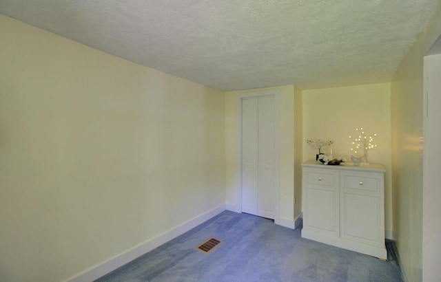 398 N Rd, Milton, VT 05468 - unfurnished bedroom with baseboards, dark colored carpet, and a textured ceiling