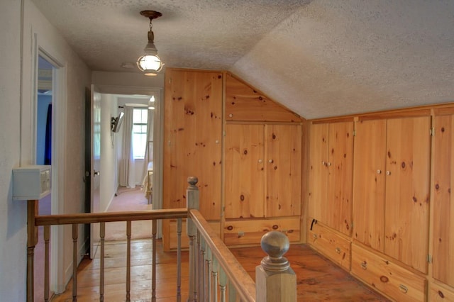 398 N Rd, Milton, VT 05468 - hall featuring a textured ceiling, lofted ceiling, light wood-style flooring, and wood walls