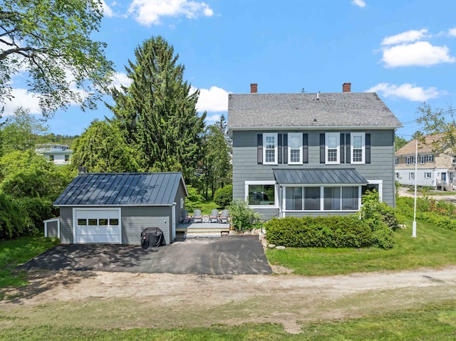 10 Wharf Rd, Center Harbor, NH 03226 - back of property with a chimney, an outdoor structure, asphalt driveway, a wooden deck, and a garage