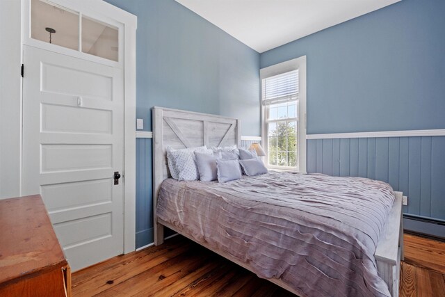 10 Wharf Rd, Center Harbor, NH 03226 - bedroom featuring wood finished floors, baseboard heating, and wainscoting