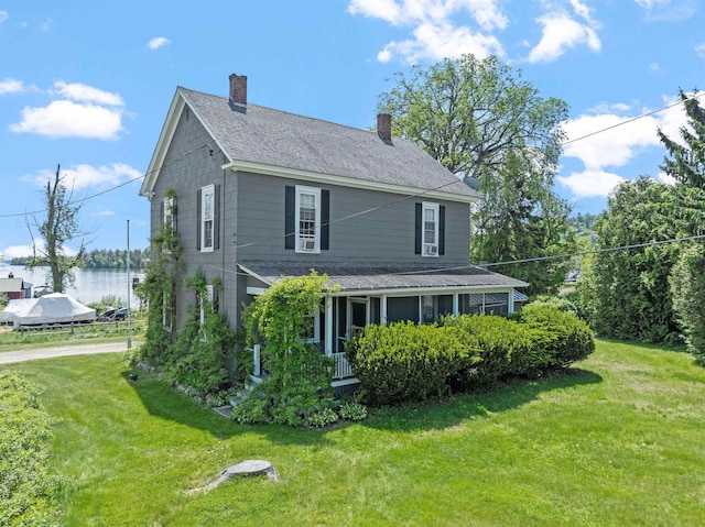 10 Wharf Rd, Center Harbor, NH 03226 - view of front of home with a front yard, a chimney, and a shingled roof