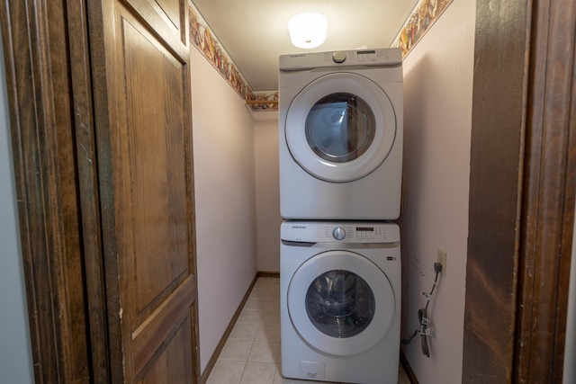 16 Berkeley St, Pelham, NH 03076 - laundry area with stacked washer and clothes dryer, light tile patterned floors, and baseboards