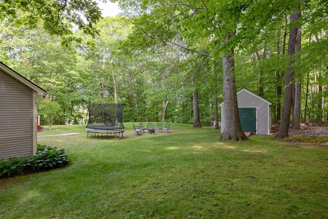 16 Berkeley St, Pelham, NH 03076 - view of grassy yard with a trampoline and an outdoor fire pit