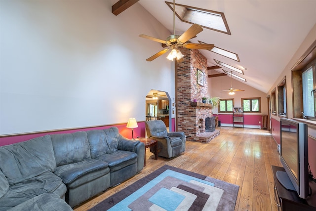 16 Berkeley St, Pelham, NH 03076 - living room featuring ceiling fan, high vaulted ceiling, light wood-style floors, beam ceiling, and a skylight