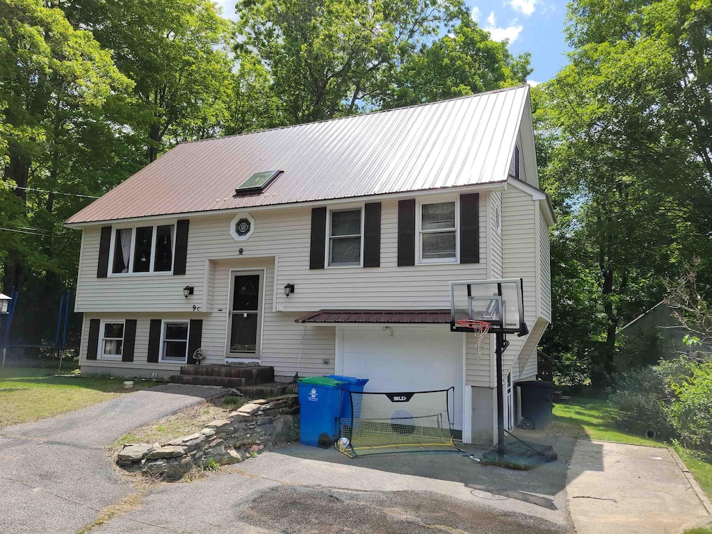 9C Kingsbury St, Derry, NH 03038 - raised ranch with driveway, an attached garage, and metal roof