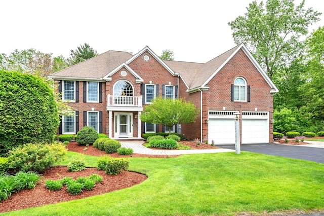 16 Gilboa Ln, Nashua, NH 03062 - colonial house featuring a garage, asphalt driveway, brick siding, a front lawn, and a balcony